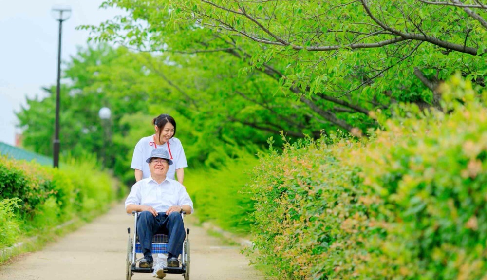 車椅子の高齢者と介護士